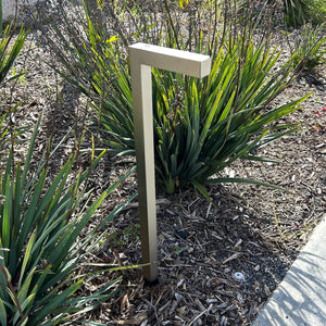 A contemporary pathway light fixture with a stainless steel finish and a clear glass lens, designed for outdoor landscape lighting.